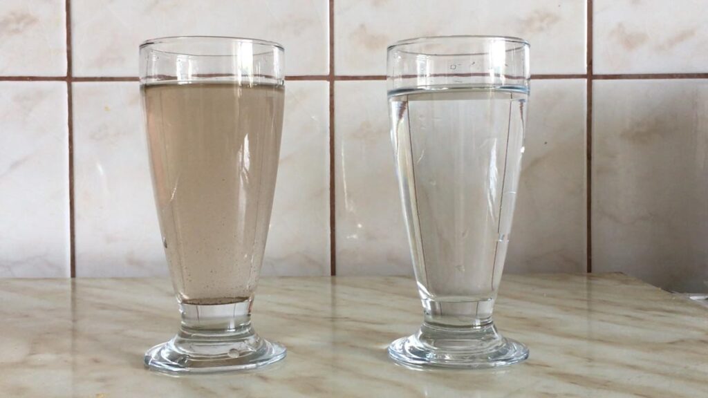 Фотографија на која се гледаат две чаши - едната со чиста, другата со матна вода.