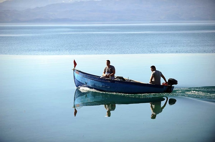 Двајца мажи пловат со чамец по Охридско Езеро.